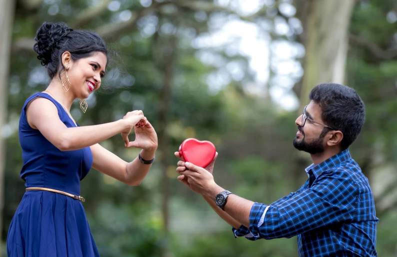 a couple that is holding a red box together