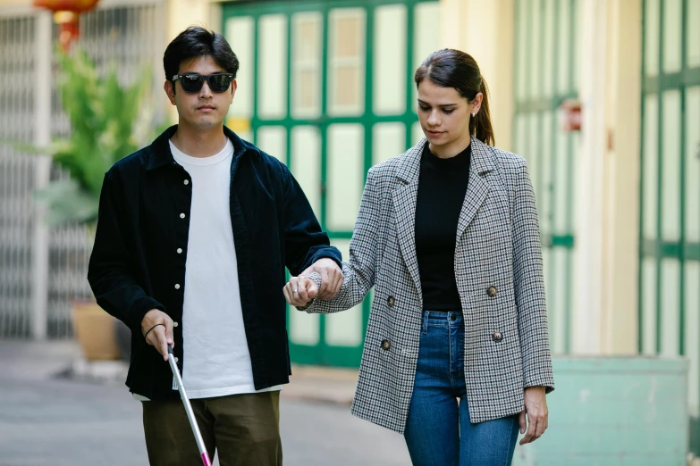 a man holding an umbrella and walking with a woman