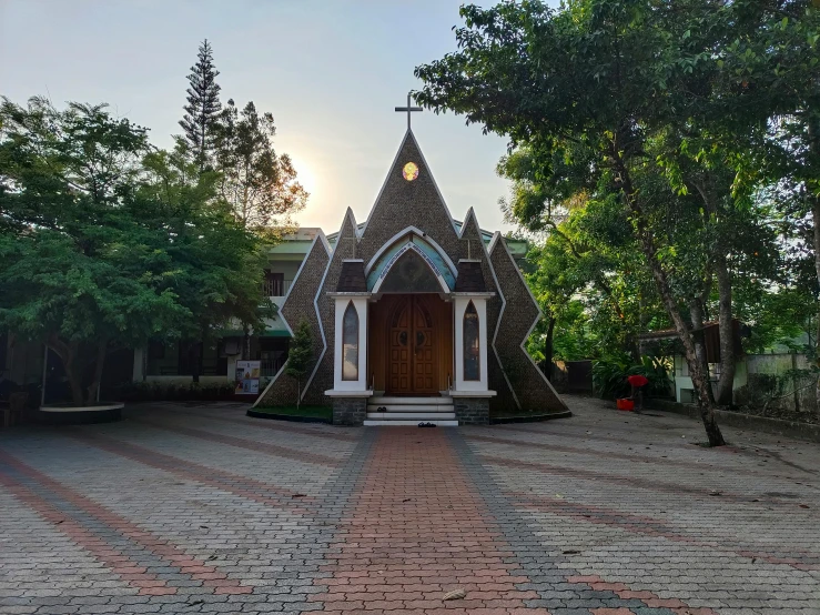 a small building has trees and people sitting in front