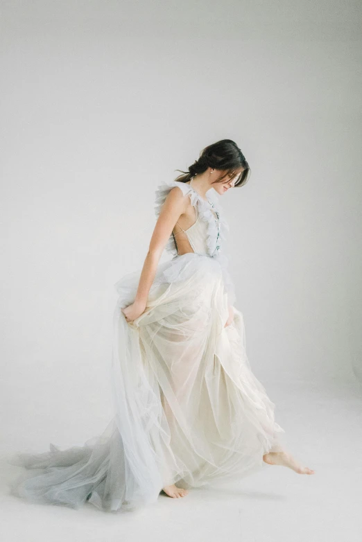 a woman standing on a white surface wearing a dress