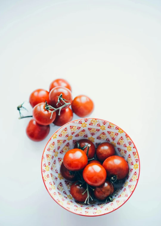 small bowls filled with red tomatoes on a white table