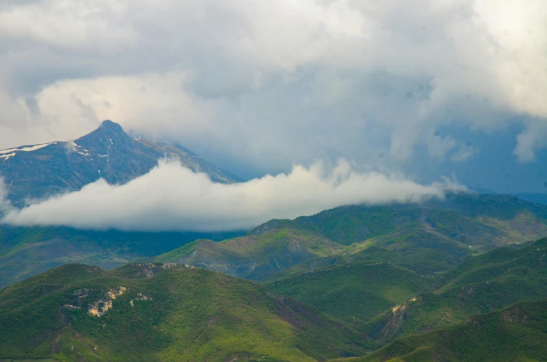 clouds drift over a snow capped mountain landscape