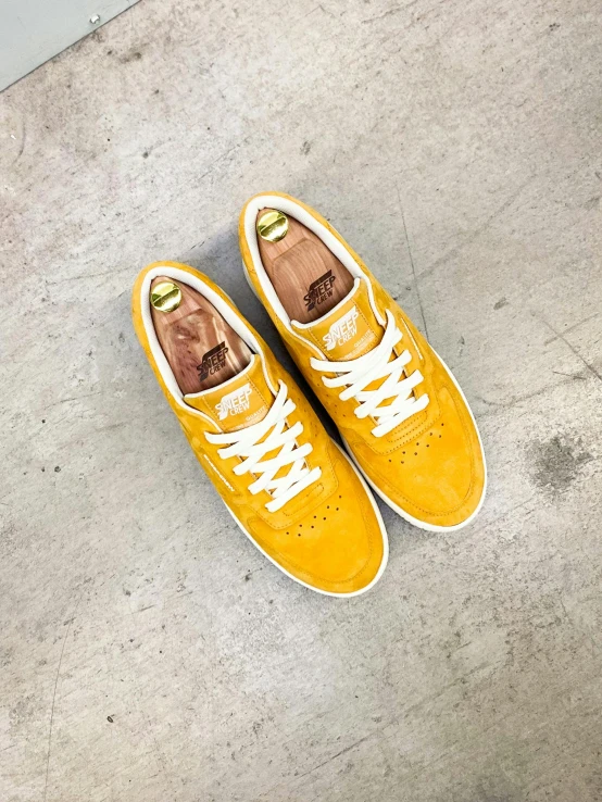 a pair of yellow shoes on concrete floor