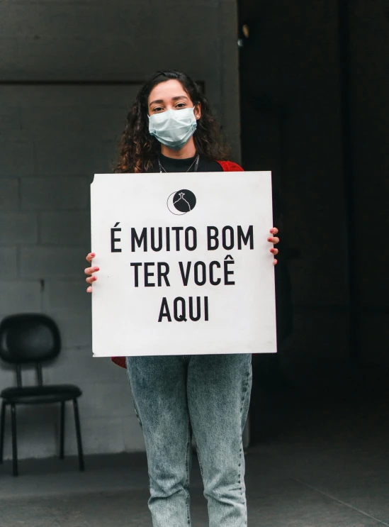 a woman is holding a sign that reads, es mutio bomb ter voce acqui