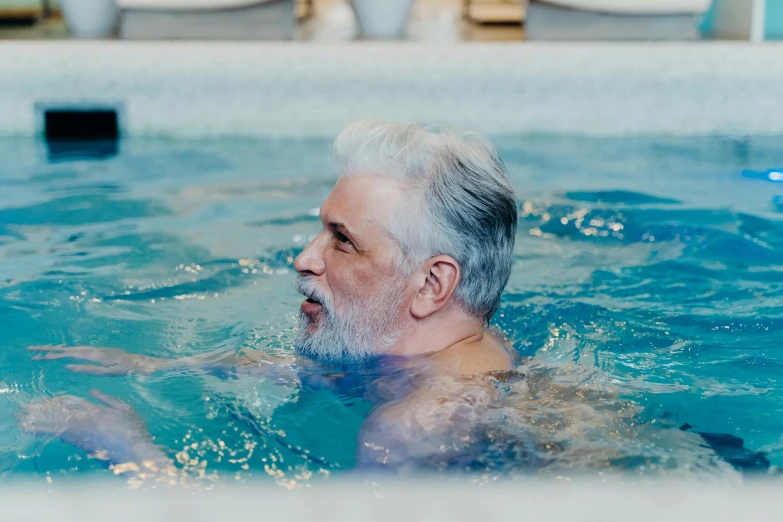 an older man is swimming in the pool