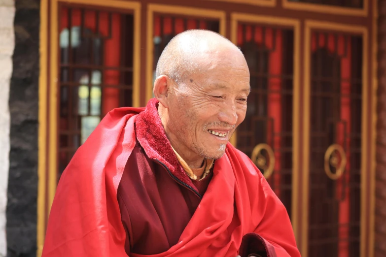 an old man with a very well - fashioned red suit and scarf is standing outside