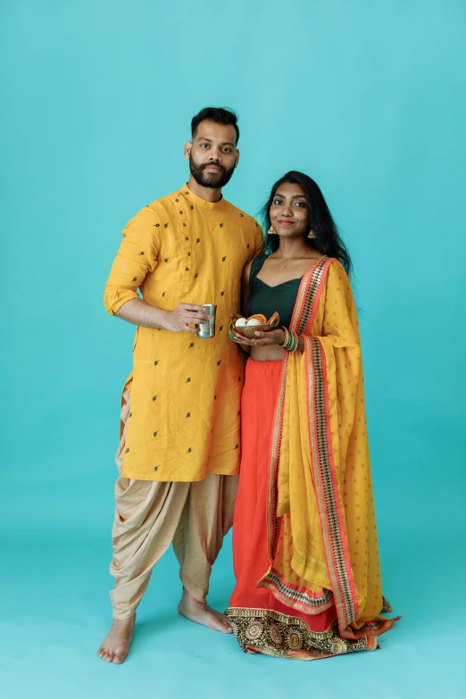 a couple pose for a pograph together while they hold tea cups