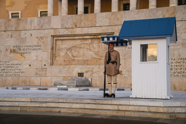 a soldier stands in front of a small building