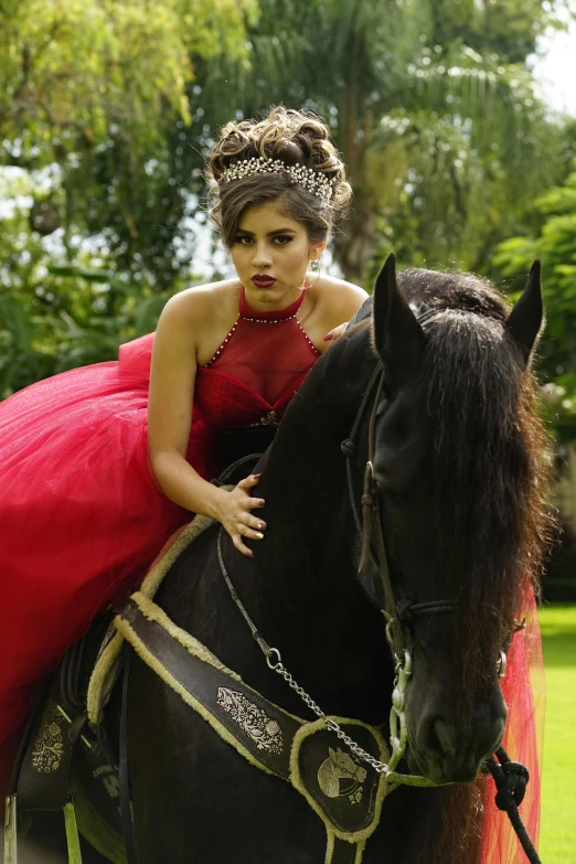 a young woman wearing red sits on a black horse