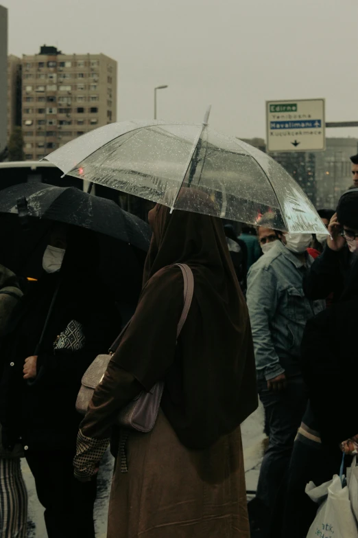 a group of people holding onto umbrellas on a city street