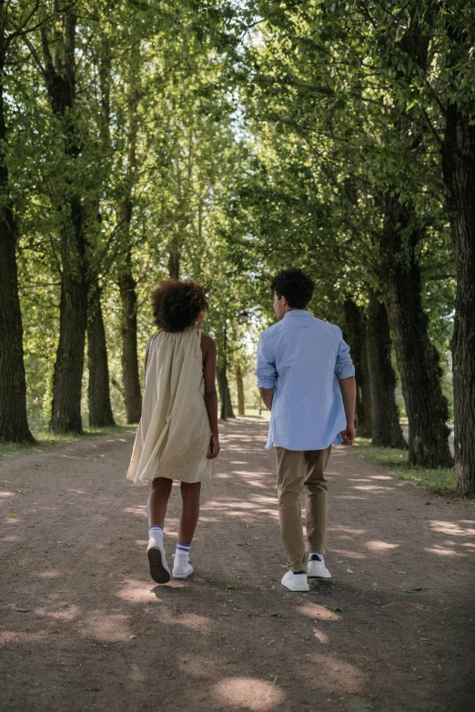 a couple walking through a park together holding hands