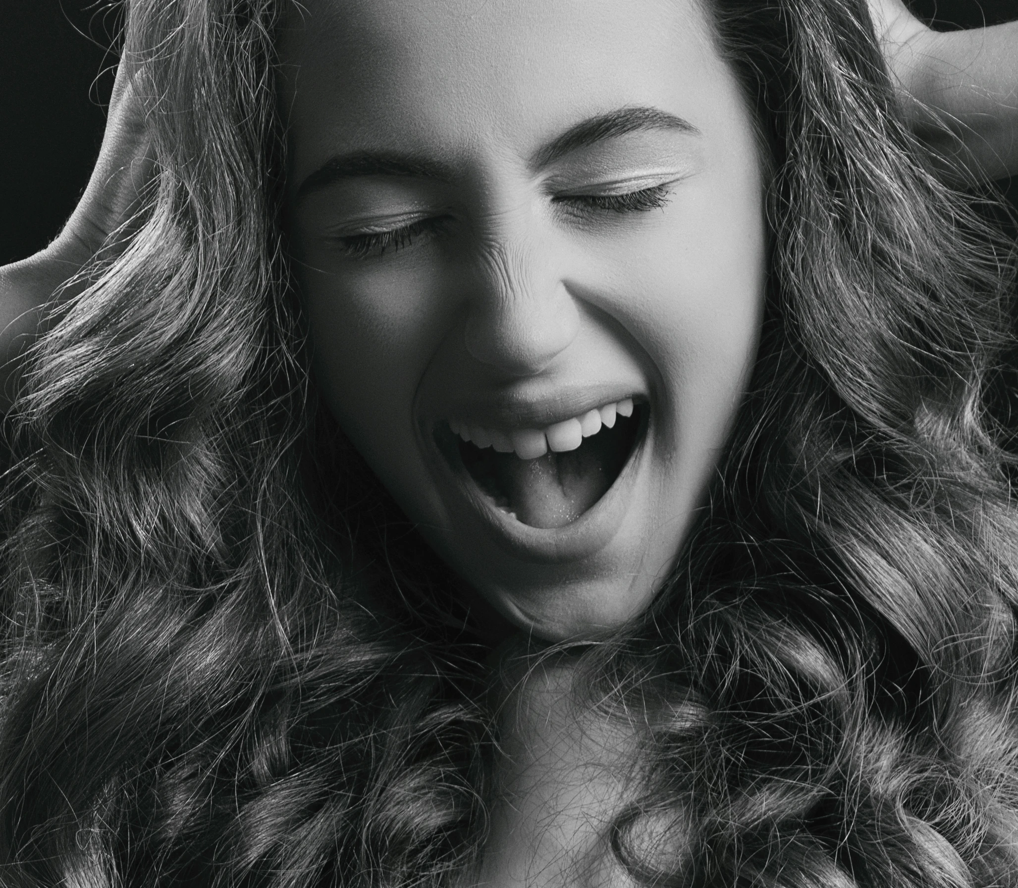 a woman laughing while she brushes her long hair