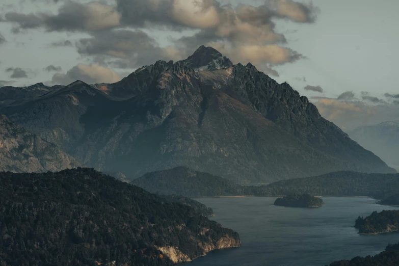 a large mountain is next to a body of water