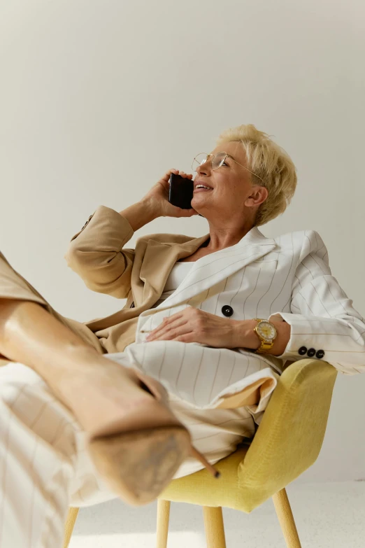 an older lady in a chair holding a phone to her ear