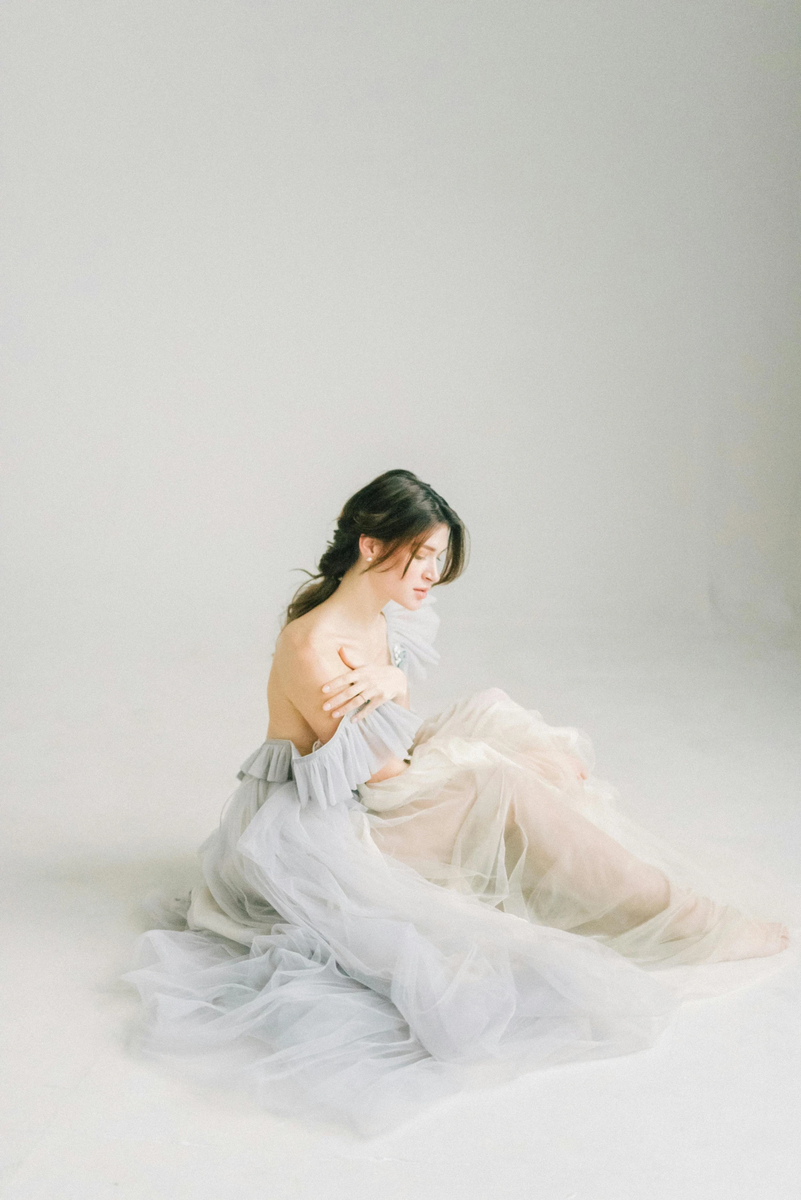 a woman sitting on the ground wearing white