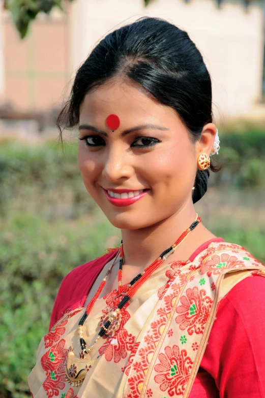 young woman with traditional jewelry smiling at the camera