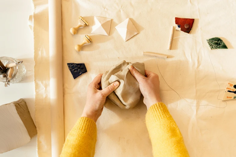 someone sews together a handbag while putting it on the surface