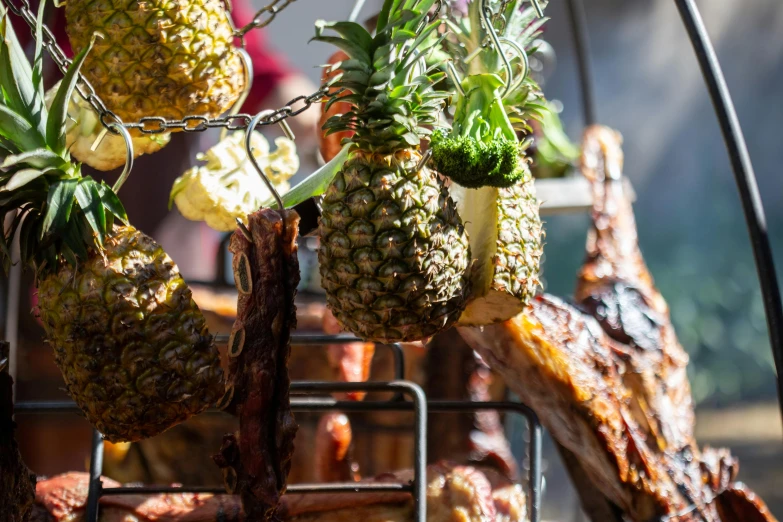 a bunch of grilled pineapples hanging from a wire rack