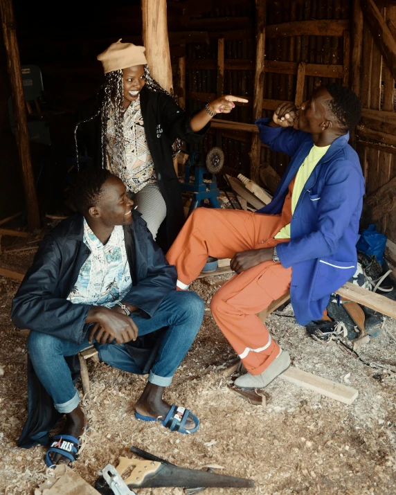 three people are sitting in a wooden building