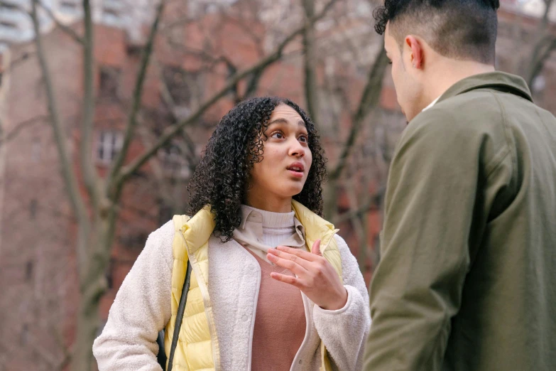 two people standing together and a man is talking