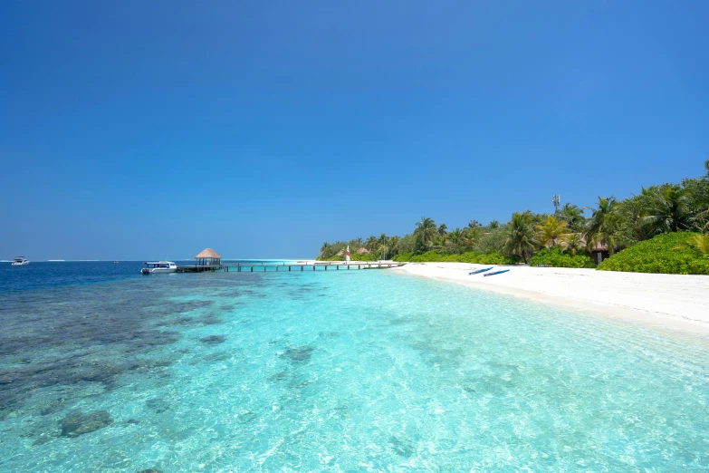 there is a beach with clear water and several houses on the sand