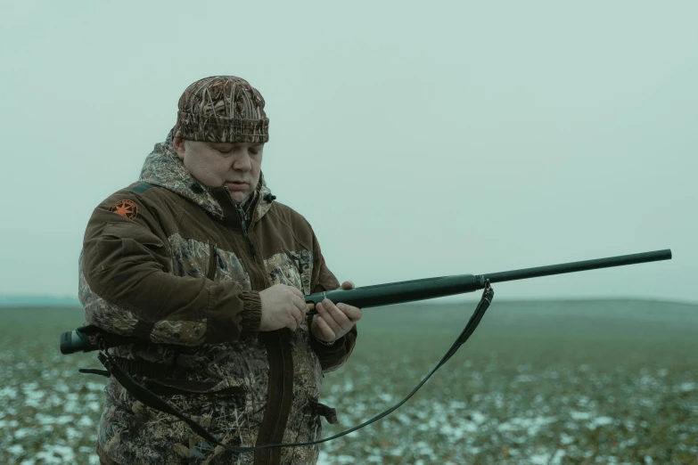 a man holds a rifle in his hand