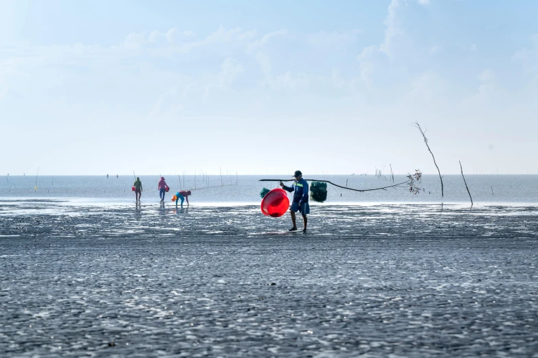 two people on the beach with water skiing in the distance