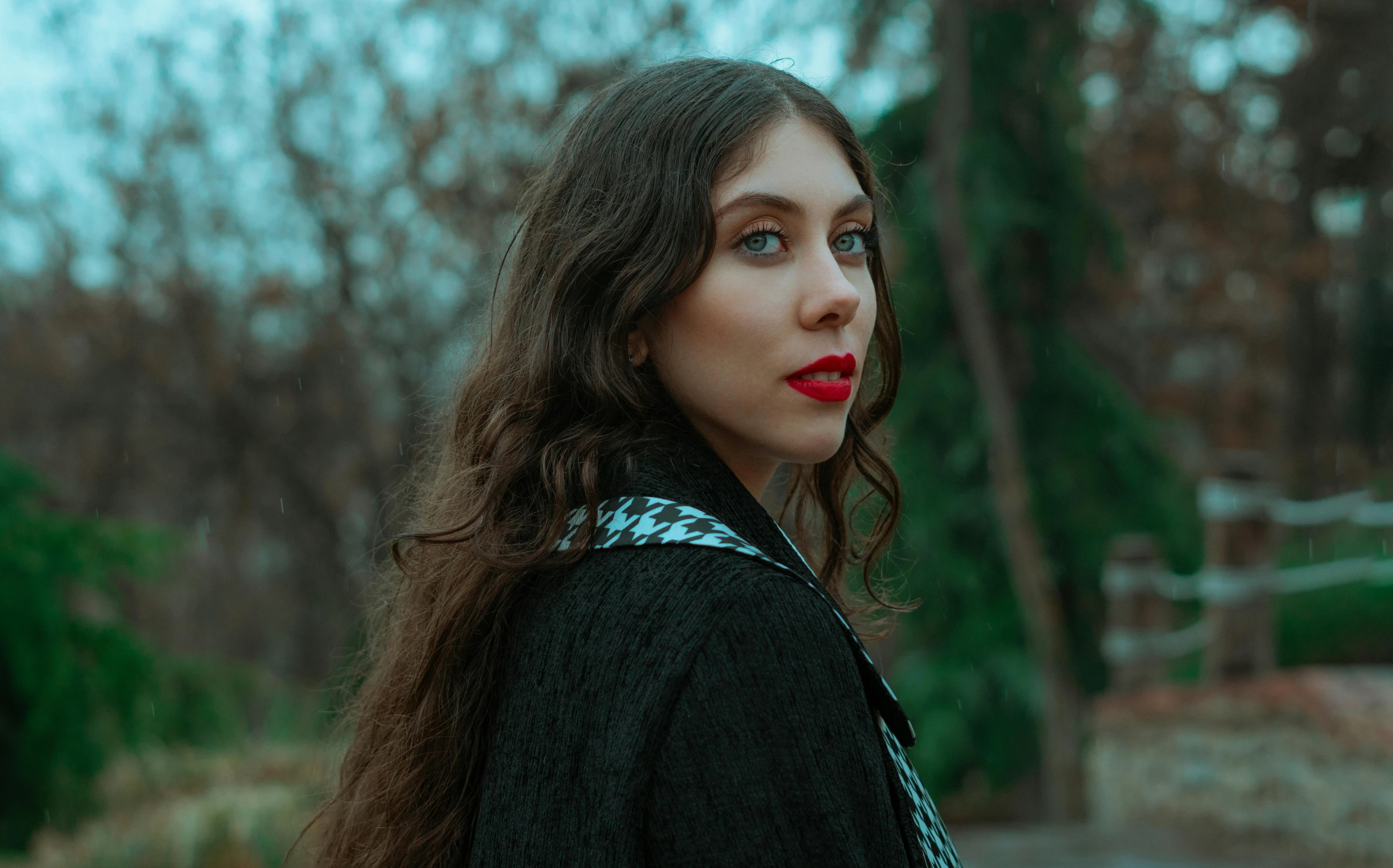 a woman with long brown hair wearing red lipstick