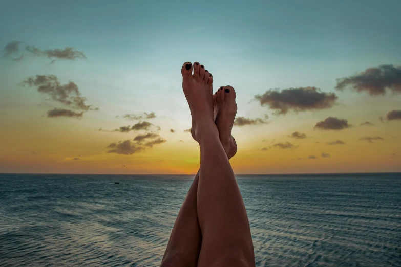 a person with their feet propped up over a body of water