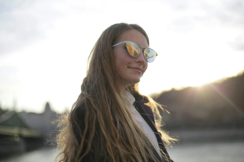 a beautiful young lady wearing sunglasses looking over her shoulder