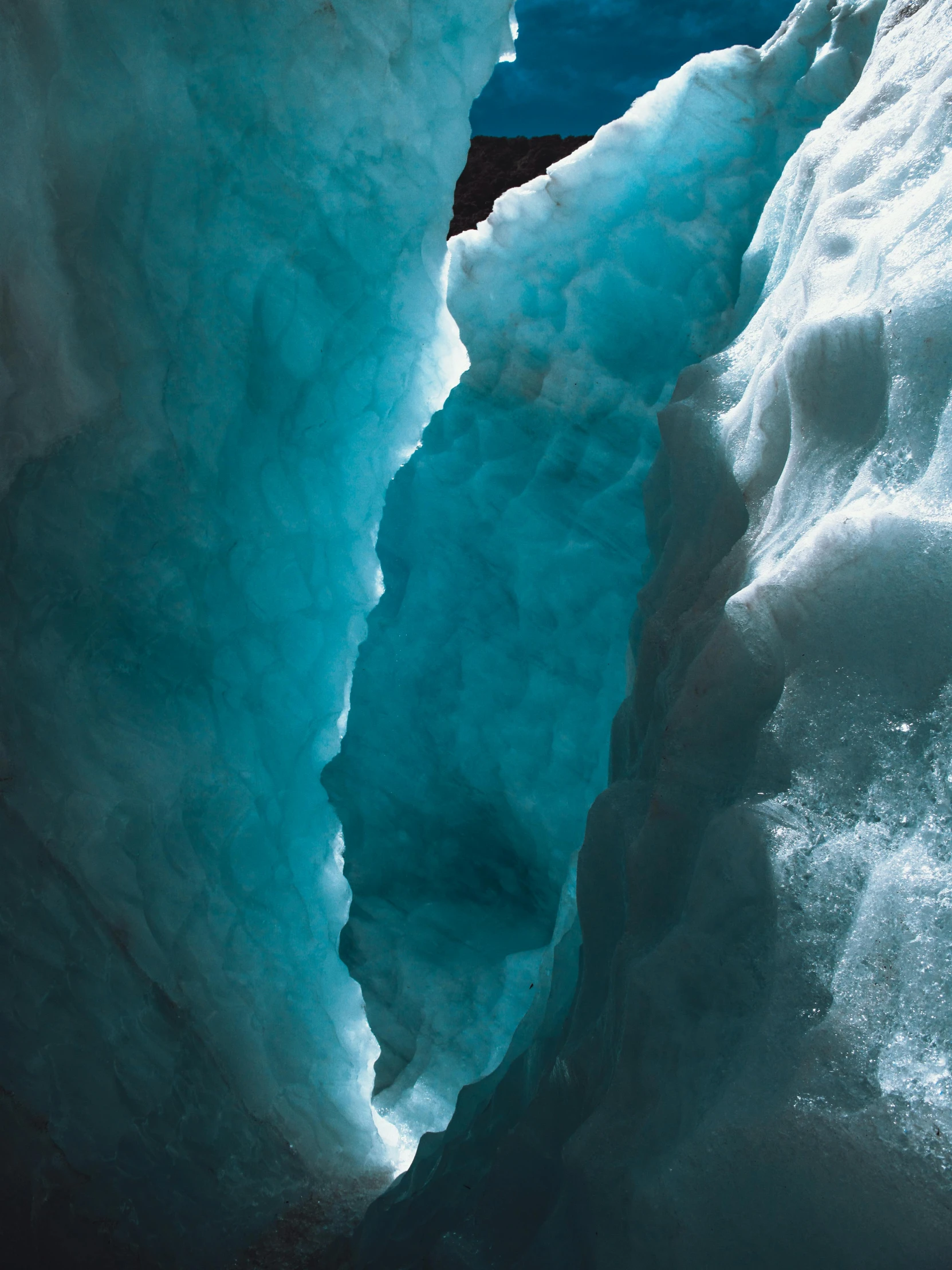 a wall of ice is partially submerged by the sunlight