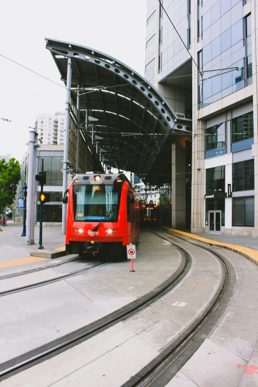 red train under a large metal covered structure