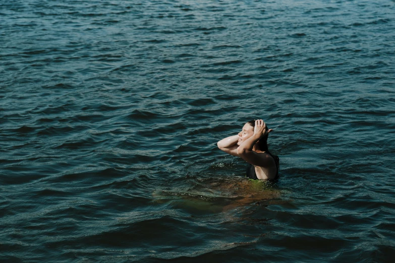 a person in the ocean raising their hands in the air