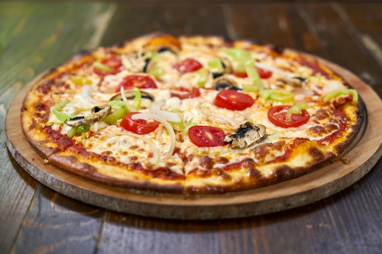 a pizza with many toppings on a wooden plate