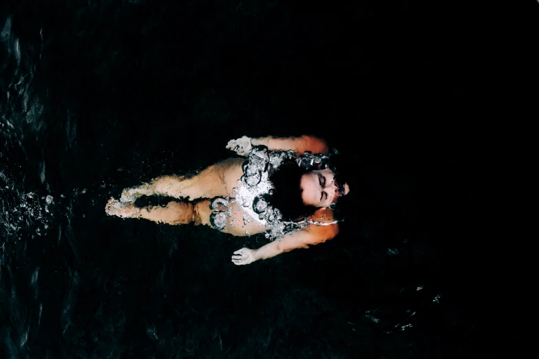 a person laying on a bed in the dark