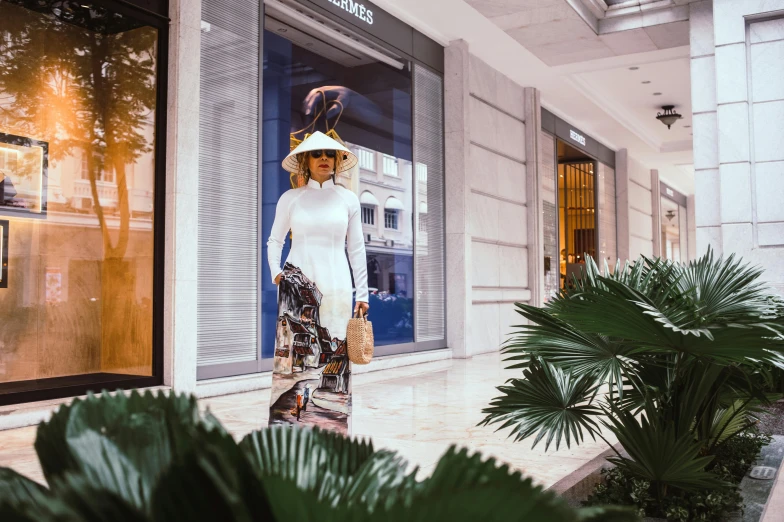 a woman is dressed in white posing outside of a building