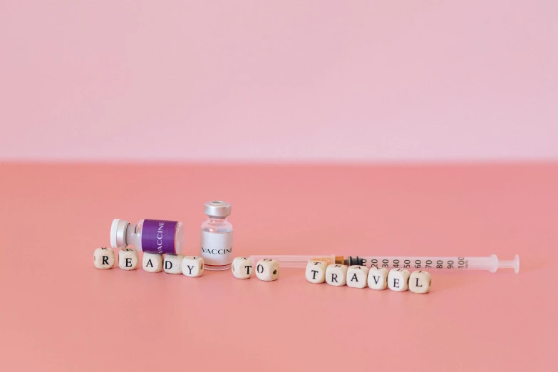 pills and a bottle sit on top of a pink surface