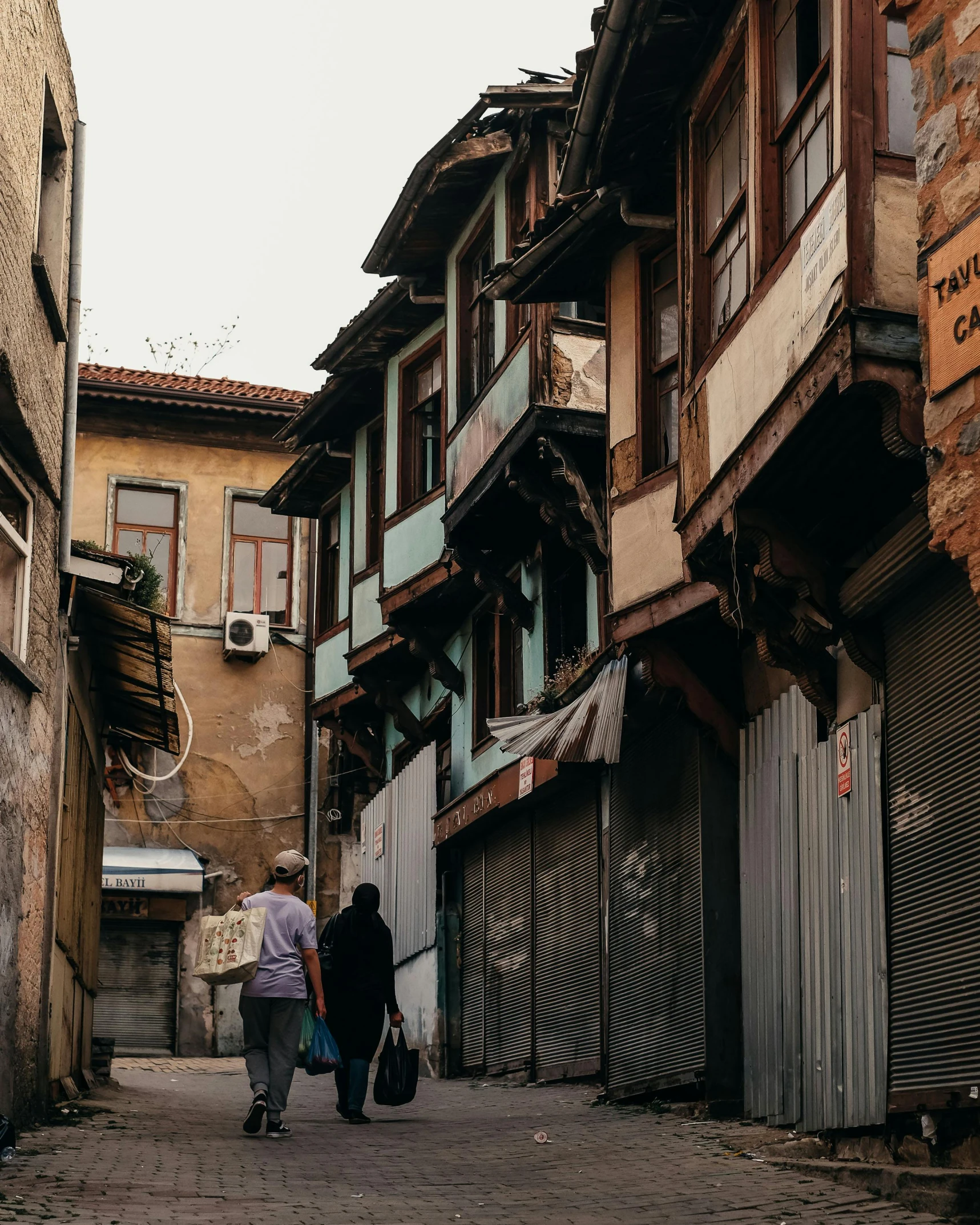 a couple of people walking down an alley way