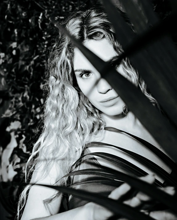 woman sitting in the shadows while holding a cellphone