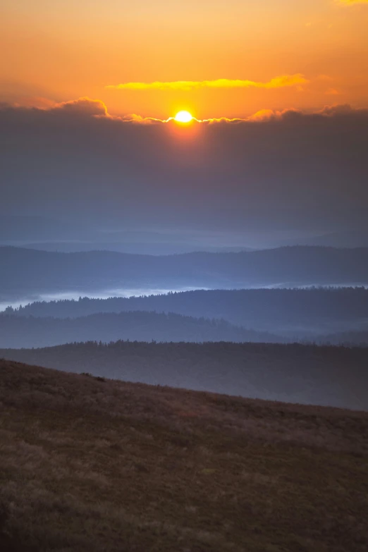 a view of the sun set over mountains