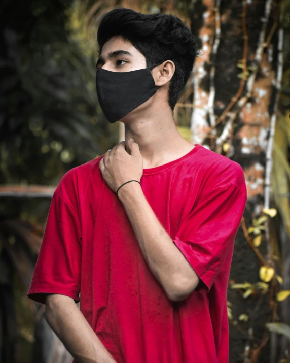 a man wearing a black mask and red shirt