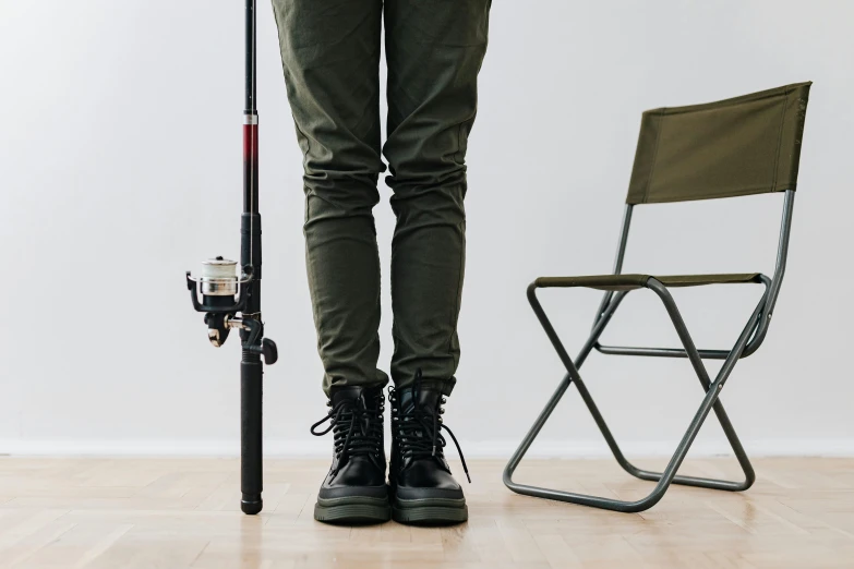 an angleer with a fishing rod and chair next to him