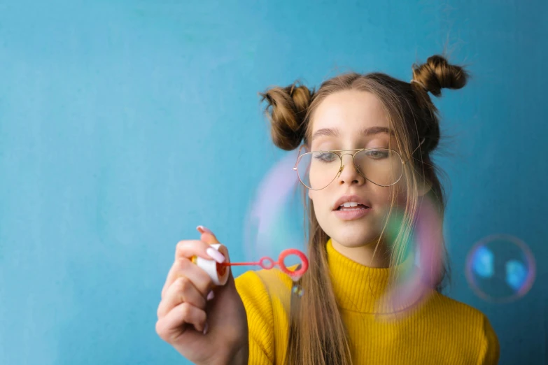 a girl blowing bubbles with a pair of scissors