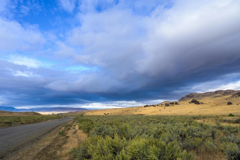 a road in the middle of a desert with a blue sky