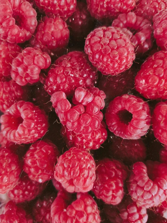 a mixture of raspberries in a bowl on a counter