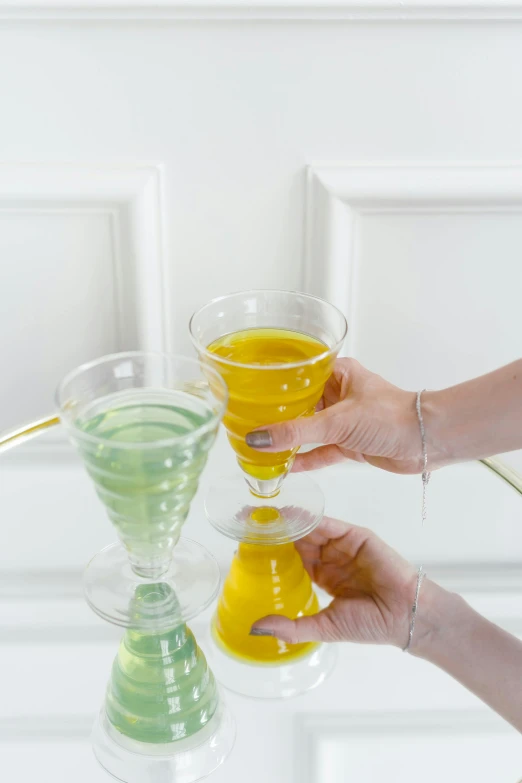 two people are holding drinks on a tray