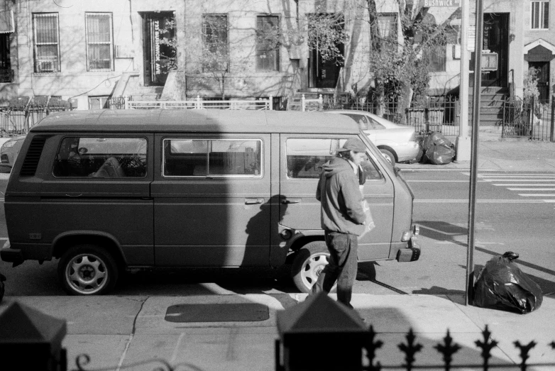 man standing in front of van next to street