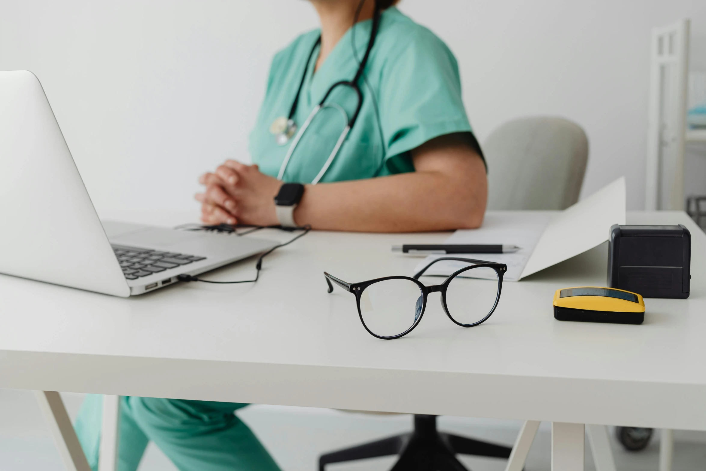 a female veterinarian in glasses and laptop sitting at a desk