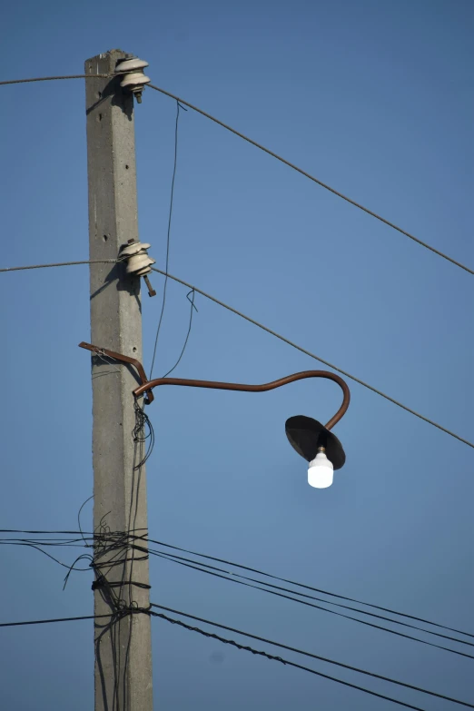 a light is hanging from the side of a pole with wires