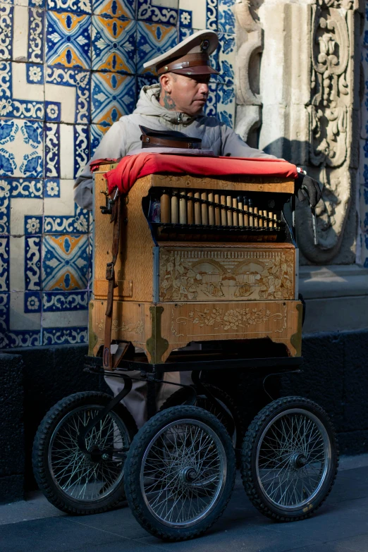 man on wagon looking over side of building